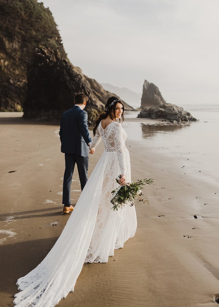 Bride in white long sleeved bridal dress with veil